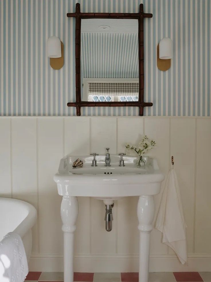 a white sink sitting under a mirror in a bathroom