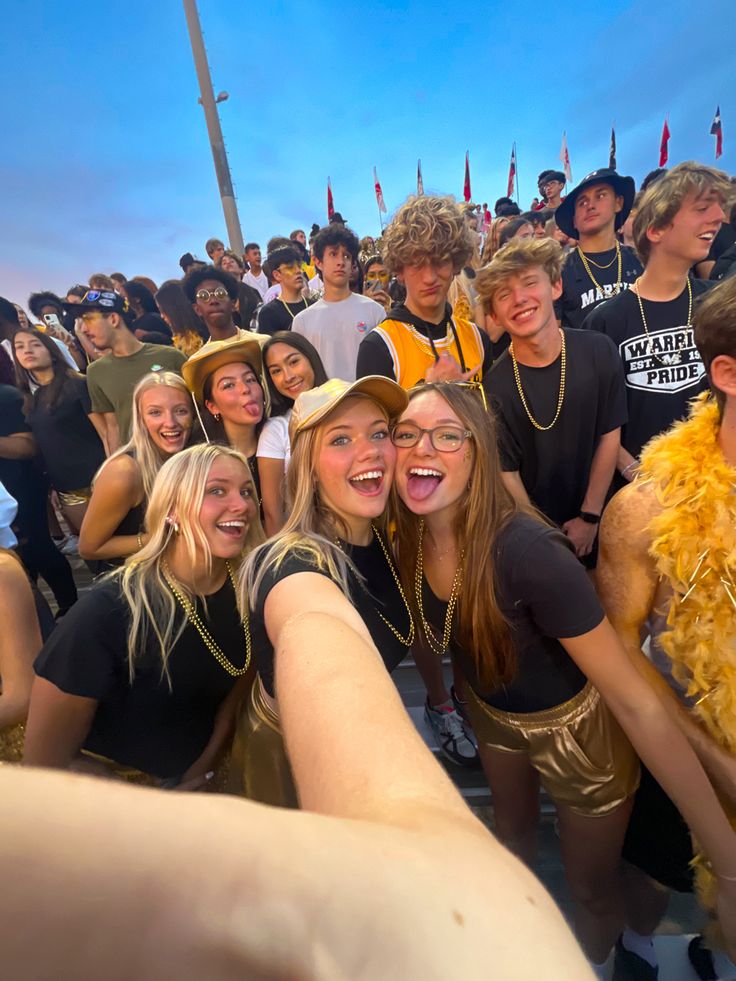 a group of young people standing next to each other in front of a large crowd