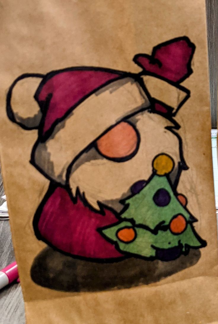 a brown paper bag with a drawing of a santa claus holding a small christmas tree