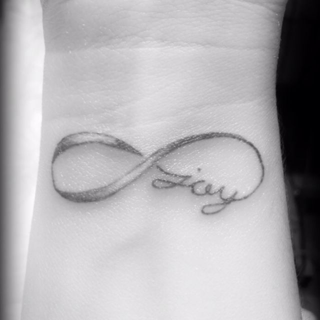 a wrist tattoo with an infinite symbol on it