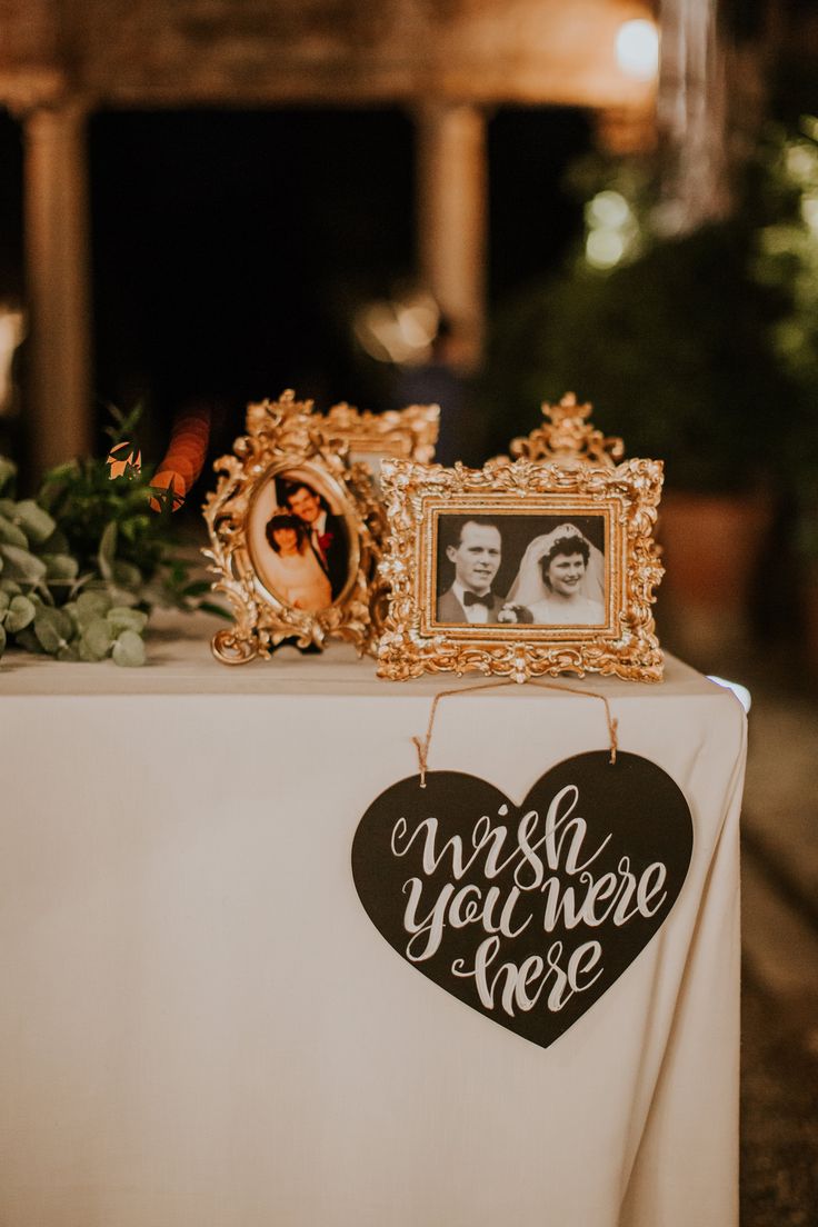 a table topped with a heart shaped sign next to a couple's wedding photo