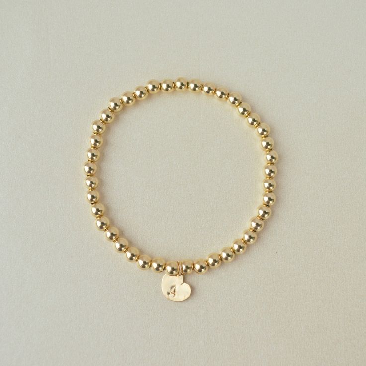 Capture everlasting memories with our Gold-Filled Beaded Bracelet featuring a personalized heart charm. Whether it's a special person or your favorite number , this classic piece is designed for daily wear, ensuring you carry your meaningful memories wherever you go. Handmade in the USADETAILS: Skin Friendly - 14K Gold-filled beadsBead Size: 4mm charm dimensions: 6.4mmx8.2mm ALL LETTERS ARE CAPITAL - Use the Personalized Box Above to write down your letter or number, in case you're shopping thro