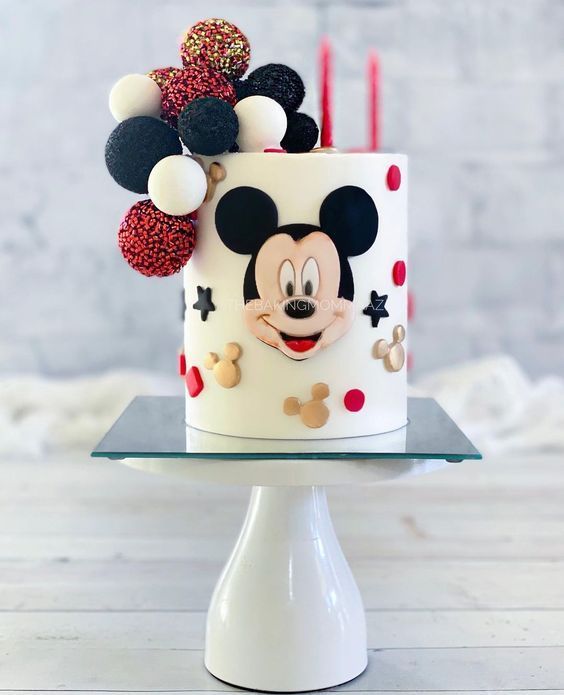 a mickey mouse birthday cake with red, white and black decorations on it's top