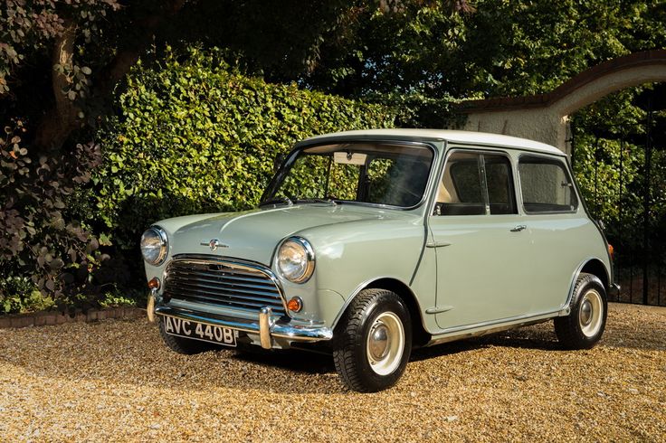 an old car is parked in front of some bushes