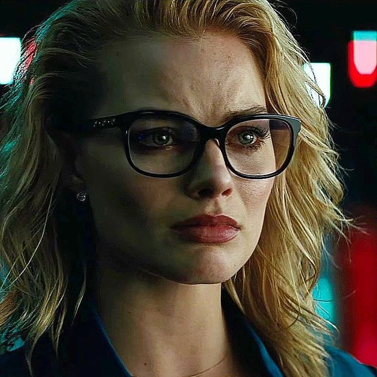 a woman wearing glasses looking at the camera