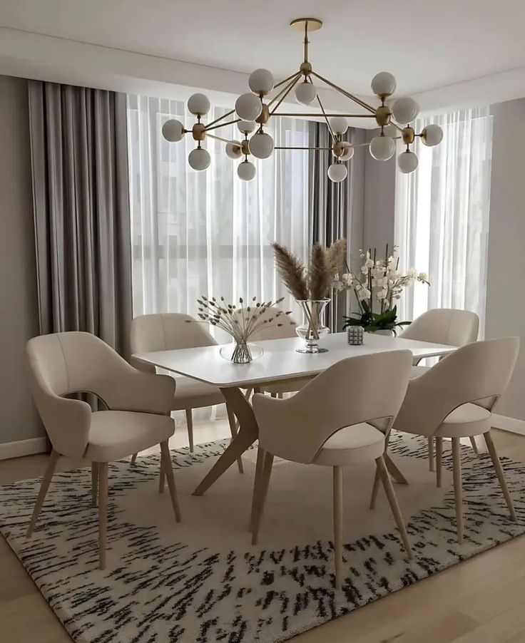 a dining room table with white chairs and a chandelier