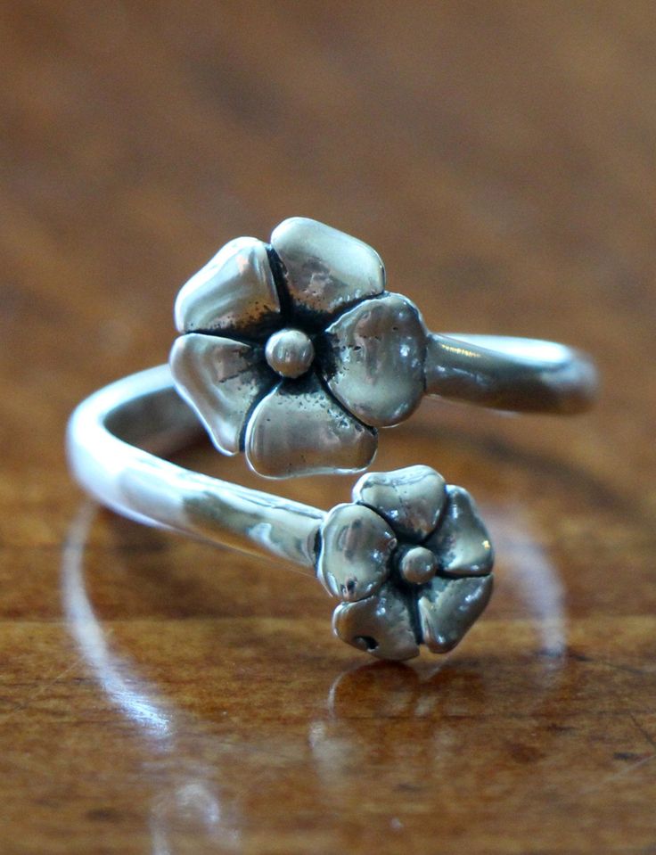 Sterling silver flower ring- beautiful jewelry gift for Mother's Day, Valentine's Day, graduation or romantic gift to declare your love during all four seasons. Sterling silver ring. Adjustable band accented with two flowers. One size fits most (5 - 10). NOTE: When resizing the ring, do not put pressure on the top of the ring. Simply size the ring to your finger but not so tight that you can't get the ring off without loosing it again. The ring should not be opened and closed over and over again Basketball Jewelry, Basketball Ring, Silver Flower Ring, Big Sister Gifts, Romantic Jewellery, Rings For Girls, Sterling Silver Flowers, Romantic Gift, Flower Ring