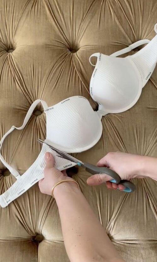 a woman is using scissors to cut off bras on a couch with brown velvet upholster