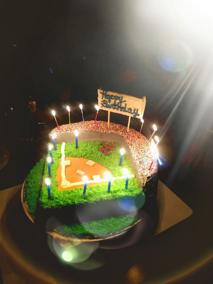 a baseball field cake with candles on it