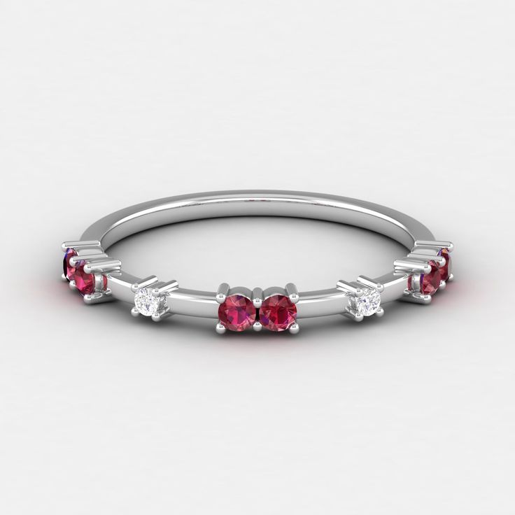 a white gold ring with three ruby stones on the side and four diamonds in the middle