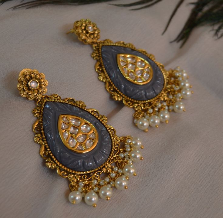 The Premium quality Kavee Amrapali inspired carved stone uncut Kundan earrings with pearl tassels. Length: Approx. 3" Push-Back Closure Antique finish - Matt Gold High-quality brass as the base metal Available in Stock. *Color may vary slightly due to light condition & photography. Jewelry Care: Keep away from moisture. Allow perfumes and lotion to dry before wearing. Store in jewelry pouch. Clean only with soft lint free cloth. Sabyasachi Earrings, Pearl Tassels, Earring Indian, Photography Jewelry, Tear Drop Earrings, Earrings Indian, Kundan Earrings, Carved Stone, Indian Earrings