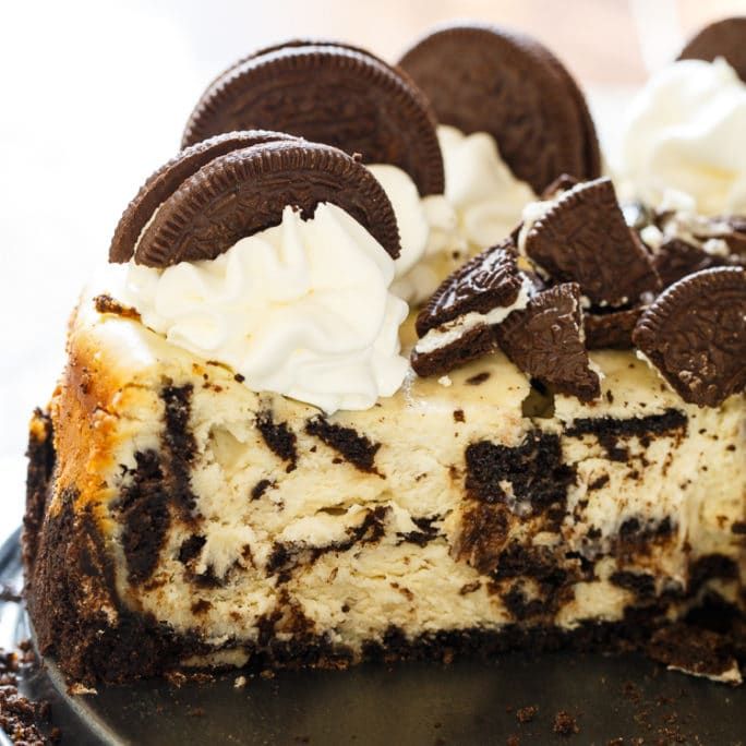 a cheesecake with oreo cookies and whipped cream