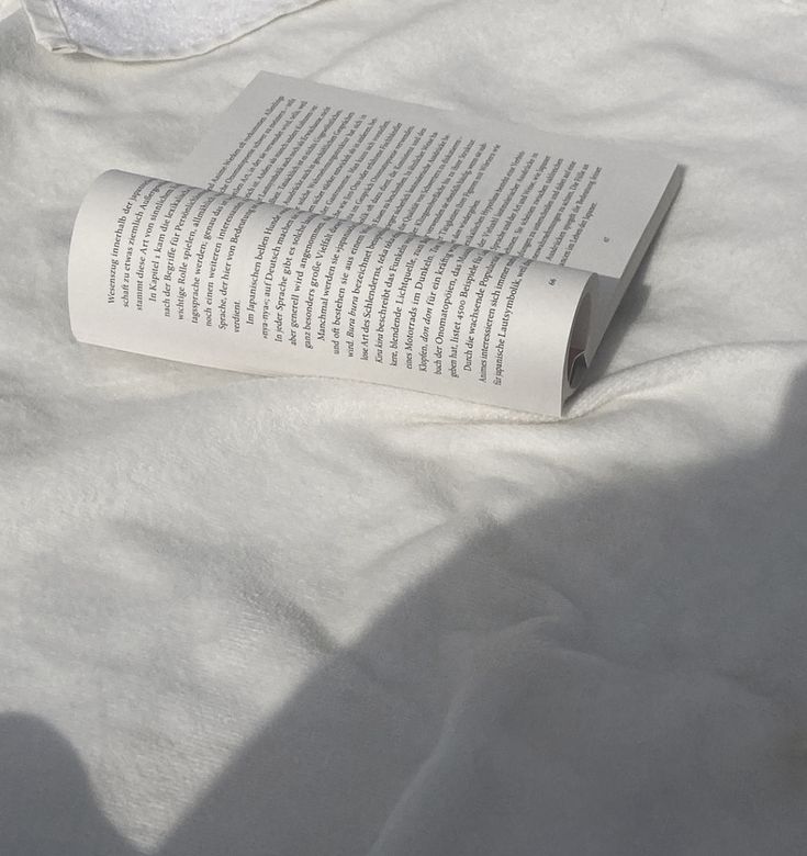 an open book sitting on top of a white sheet