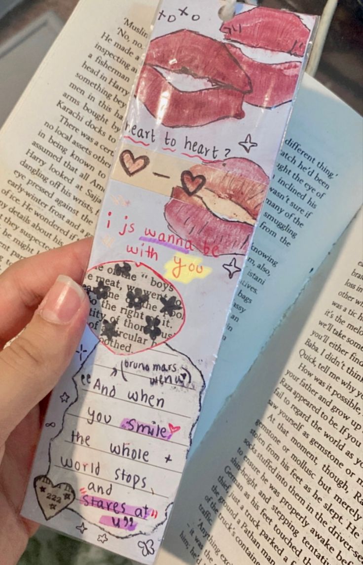 someone is holding up a bookmark with lipstick on it