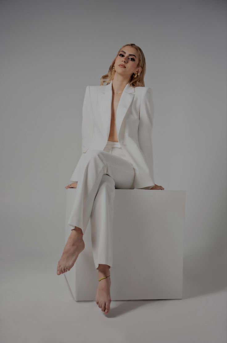 a woman sitting on top of a white box