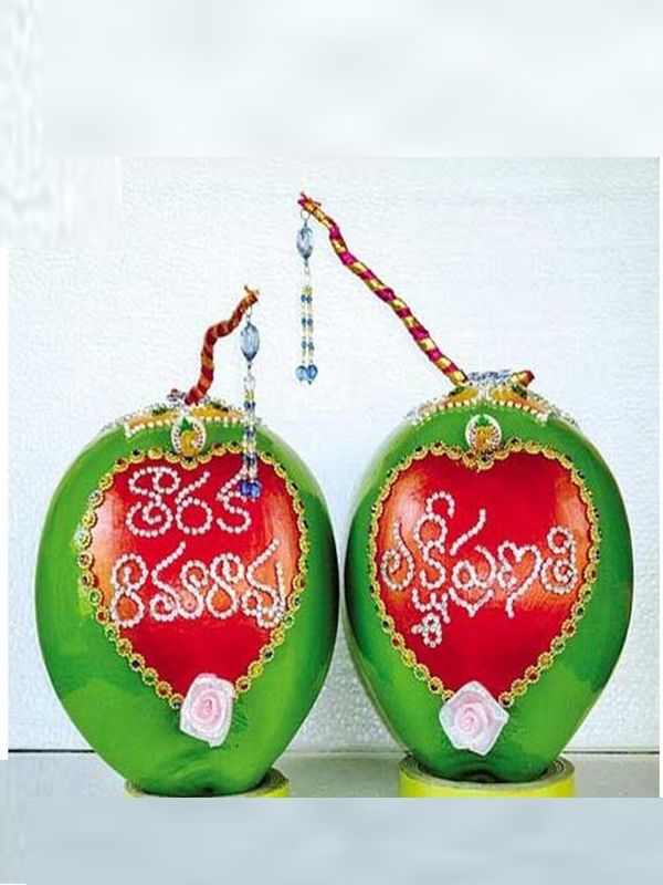 two green and red apples with designs on them sitting next to each other in front of a white wall