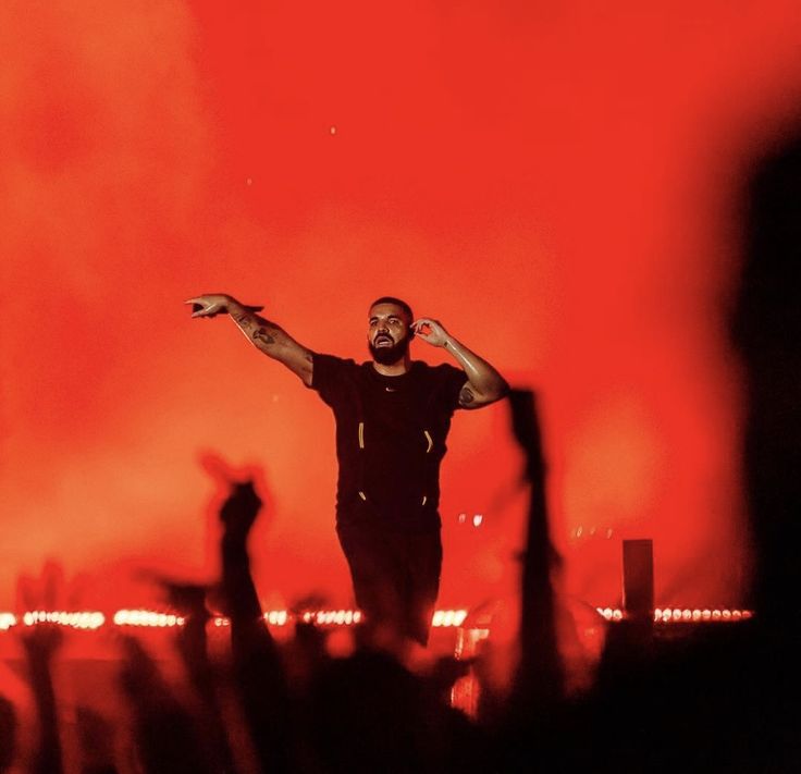 a man standing on top of a stage with his arms in the air