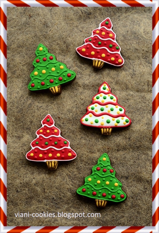 cookies decorated with christmas trees are on the sand