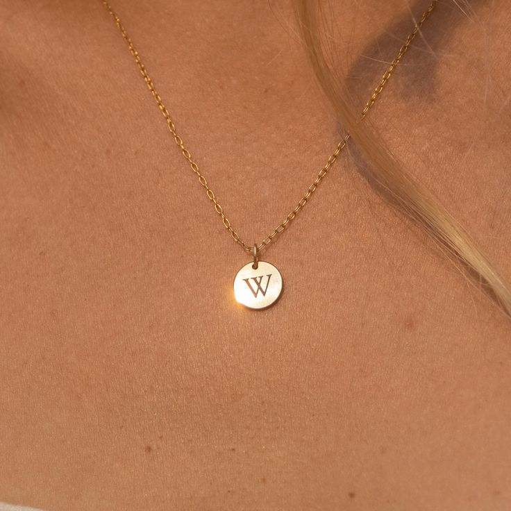 "Our tiny circle initial necklace is a fun choice when you want to make a simple, discreet statement of any single letter, number, or character that you feel defines you the best. Made of 14K gold-filled, the shiny finish disc comes on a dainty and delicate chain, giving you a truly minimalist look. Free Engraving for a limited time! NECKLACE DETAILS ⚬ 14k gold-filled disk (s) and chain. ⚬ Disc measures 10mm (.39\"). ⚬ Chain in your choice of 16\", 18\" or 20\" length ⚬ Personalized engraving of Minimalist Round Pendant Charm Necklace For Anniversary, Minimalist Name Necklace With Round Pendant And Delicate Chain, Minimalist Yellow Gold Initial Necklace For Personalized Gift, Minimalist Round Name Necklace, Minimalist Everyday Round Initial Necklace, Simple Tiny Initial Pendant Charm Necklaces, Simple Tiny Initial Pendant Charm Necklace, Minimalist Everyday Name Necklace With Round Pendant, Minimalist Initial Round Disc Necklace For Personalized Gift