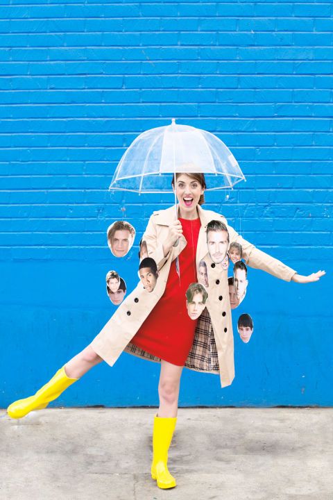 a woman in red dress and yellow rain boots holding an umbrella with photos of children on it