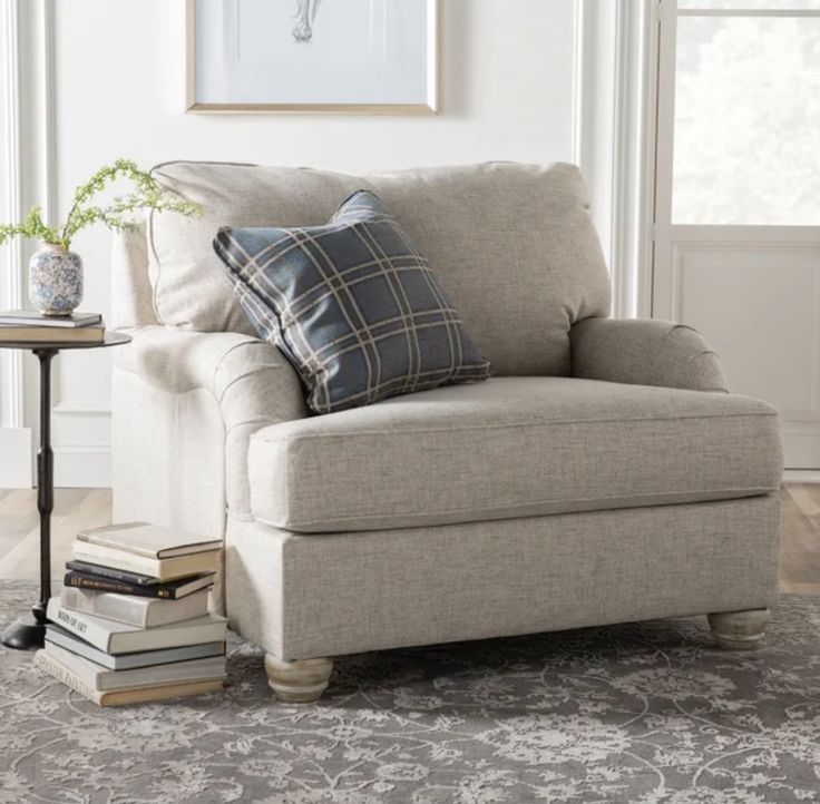 a living room with a chair and books on the floor