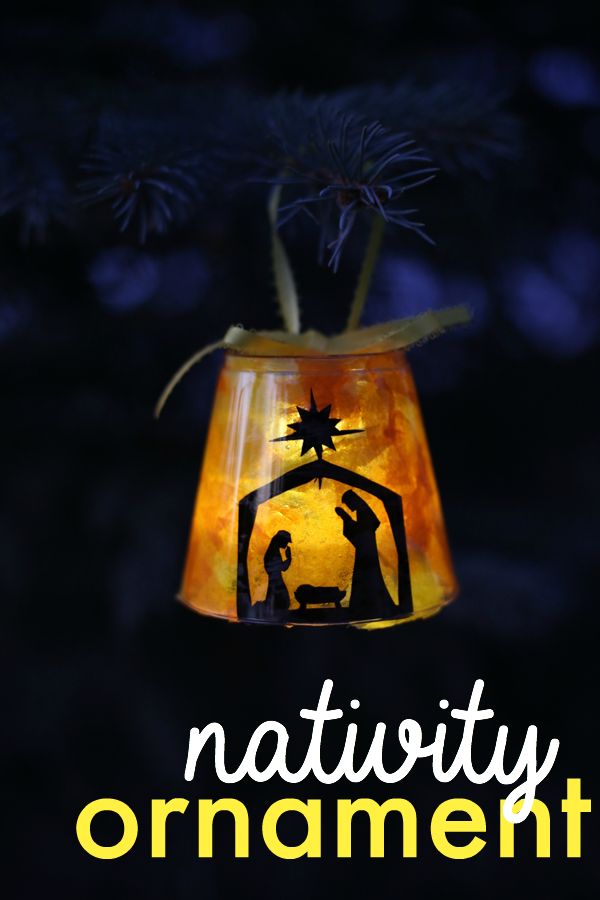 a nativity ornament hanging from a pine tree with the words nativity on it