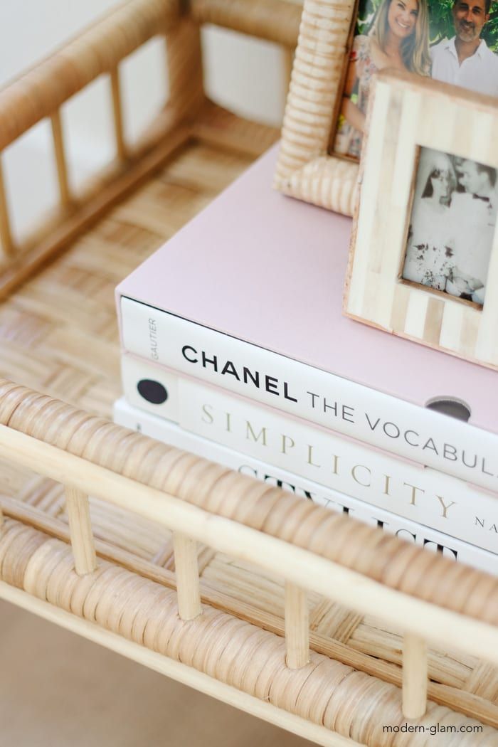 two books sitting on top of each other next to a wooden shelf with pictures and frames