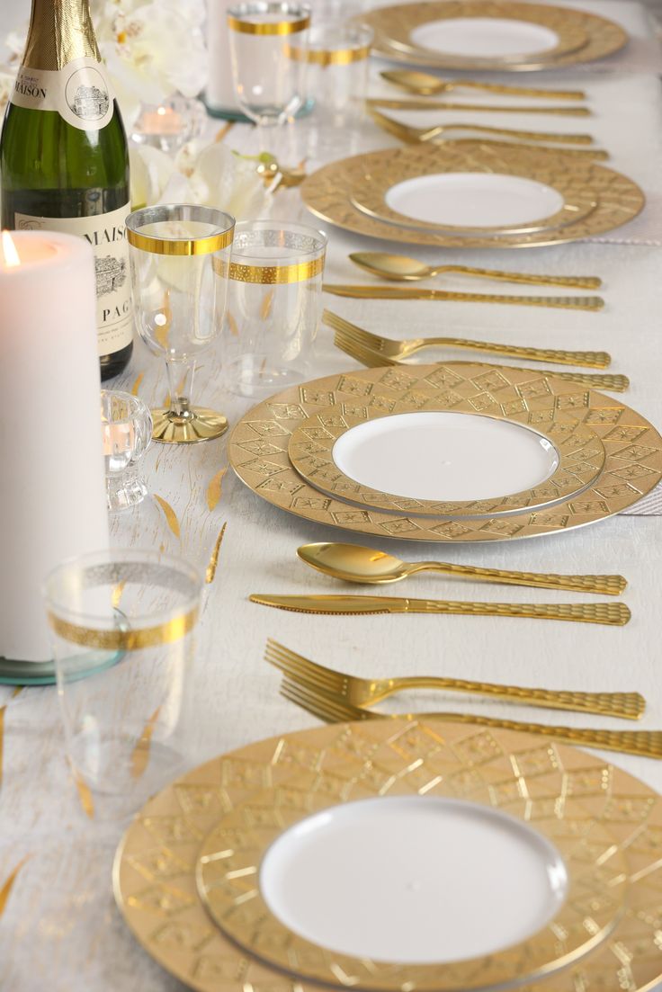 the table is set with gold and white plates