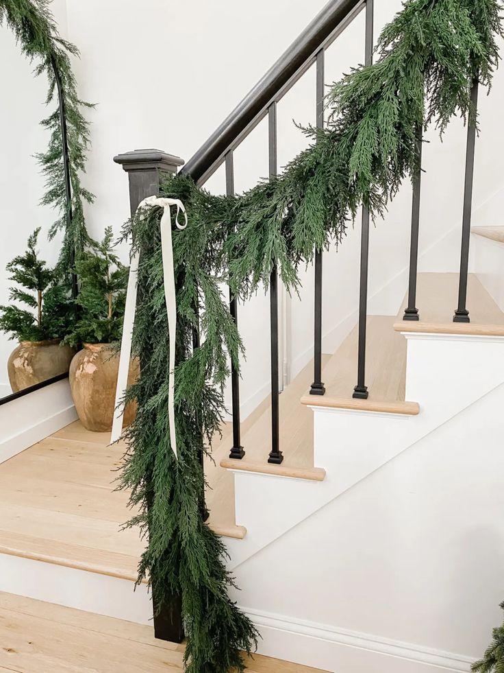 the garland is tied on the banister for christmas