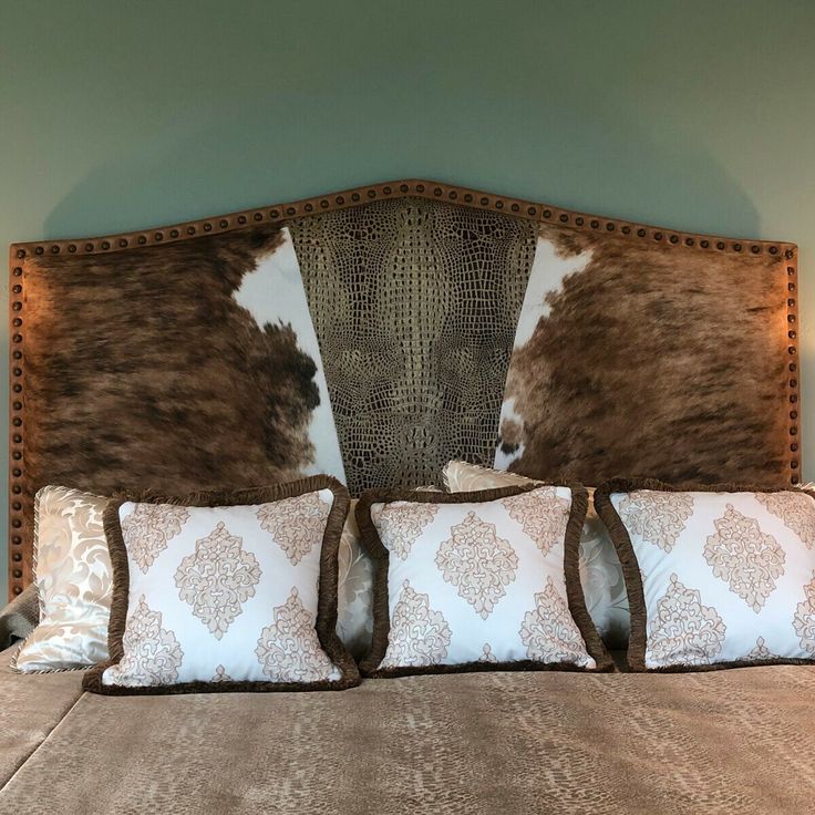 a bed with two brown and white pillows on it's headboard in a bedroom