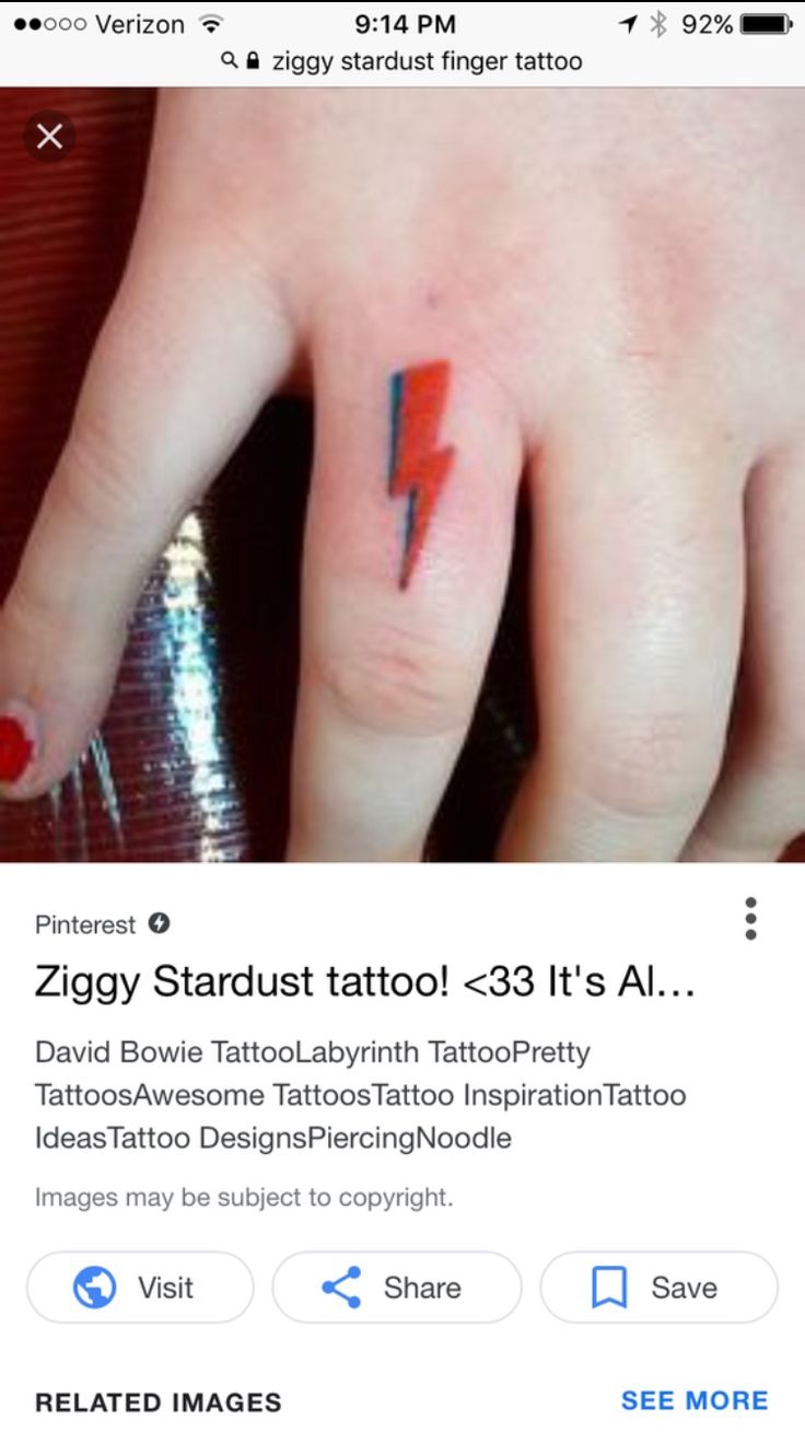 a person's hand with a red and black lightning bolt tattoo on their finger