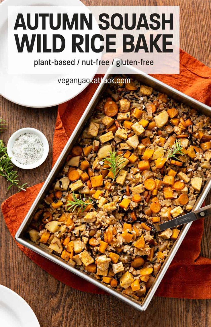 a baking pan filled with autumn squash and rice bake on top of a wooden table