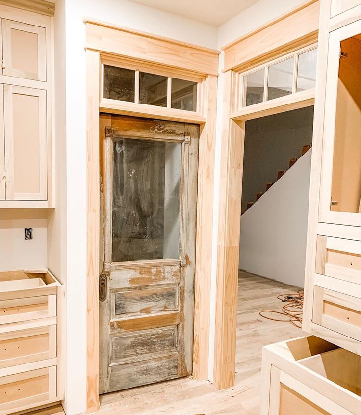 an unfinished room with wooden doors and drawers