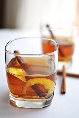 two glasses filled with tea and cinnamon sticks