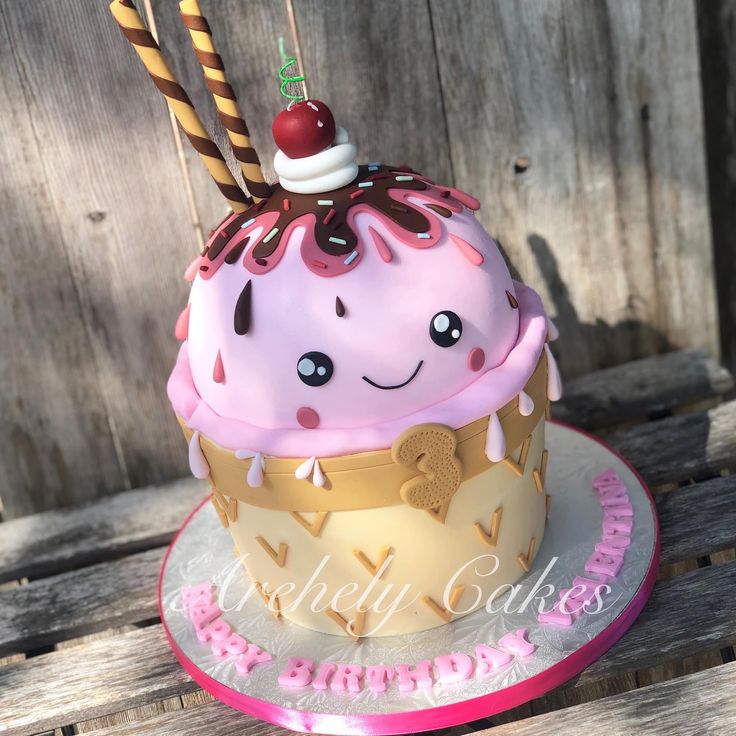 a birthday cake with pink frosting and sprinkles is on a wooden table