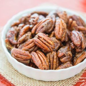 a white bowl filled with pecans on top of a table