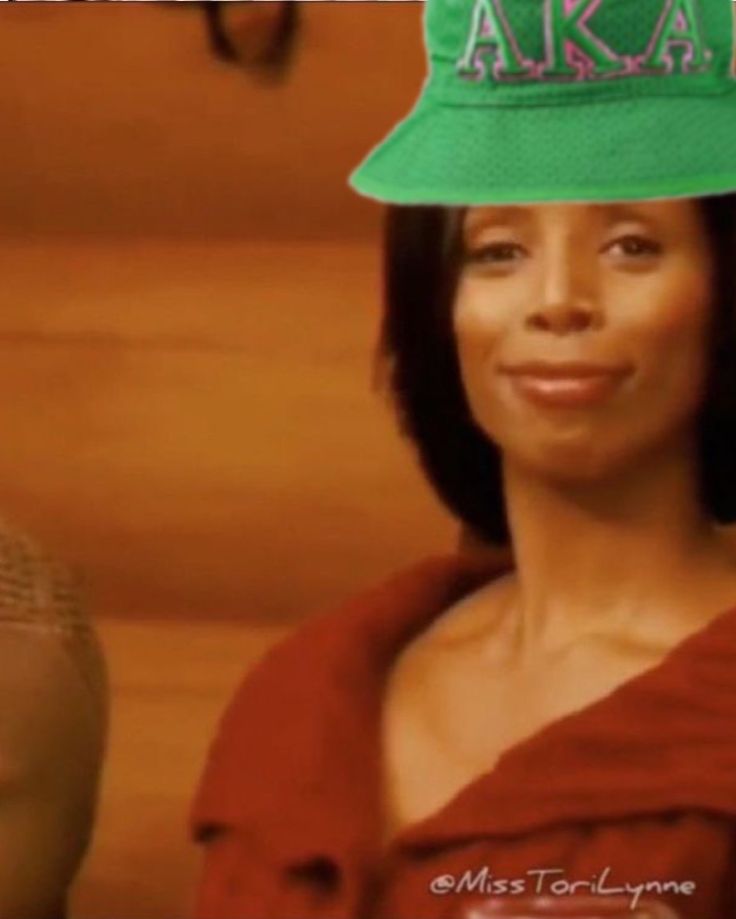 a woman wearing a green hat with the word aka on it