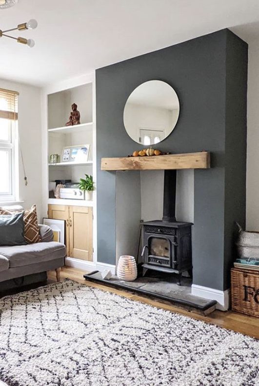 a living room filled with furniture and a mirror on top of a fireplace mantel