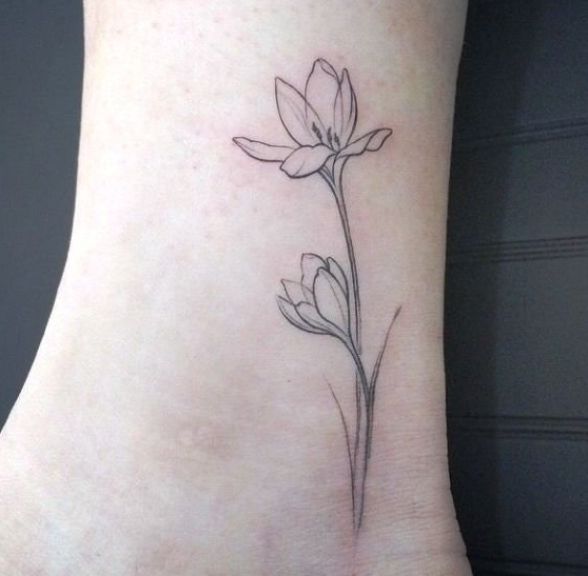 a small flower tattoo on the ankle