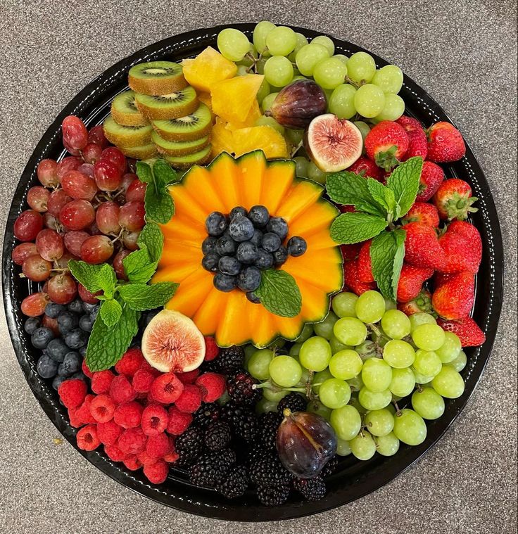 a platter filled with fruits and vegetables on top of a table