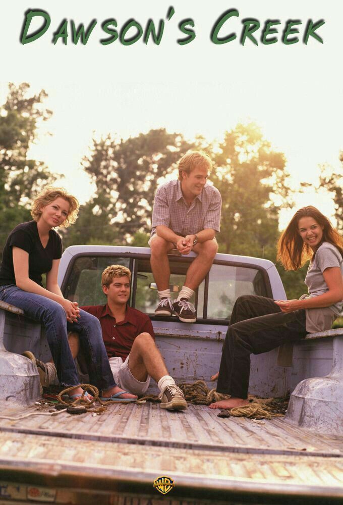 three people sitting on the back of a pick up truck