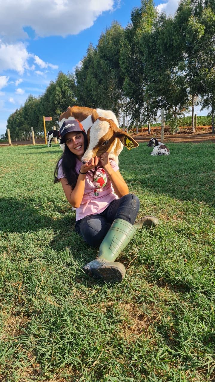 a woman kneeling in the grass with a dog on her back