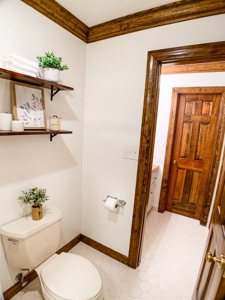 a white toilet sitting in a bathroom next to a wooden door