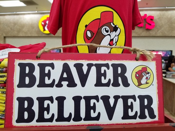 a sign that says beaver believer hangs on a shelf in a store with other items