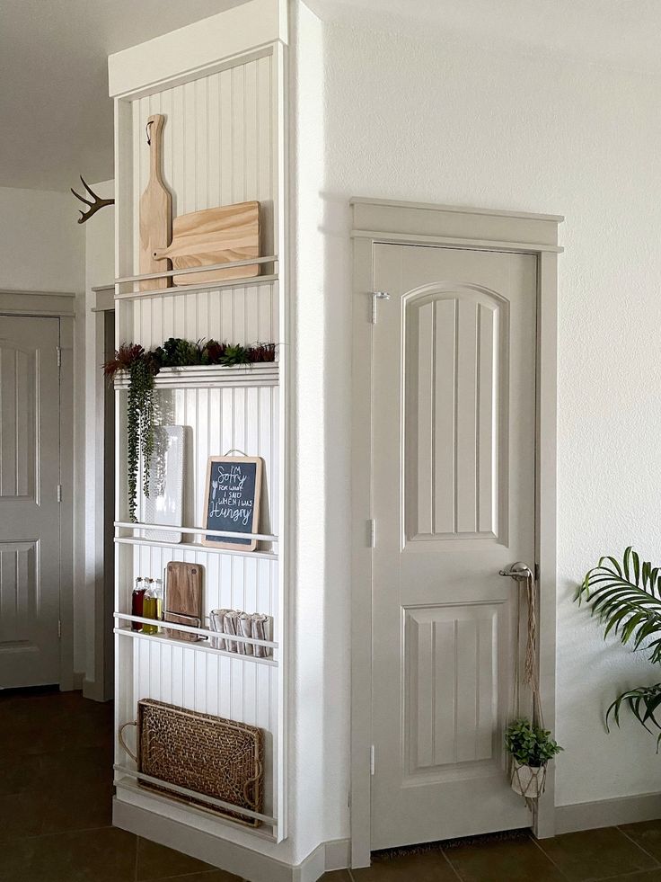 a white book shelf filled with books next to a door