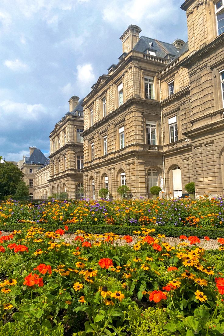 an old building with many windows and flowers in the foreground