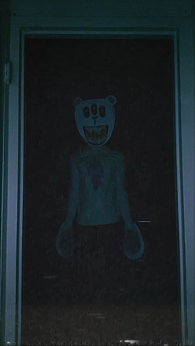 a creepy looking teddy bear standing in front of a door with its mouth open and eyes wide open