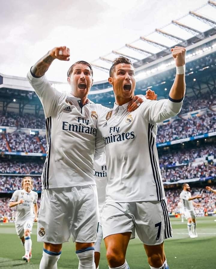 two soccer players are celebrating on the field