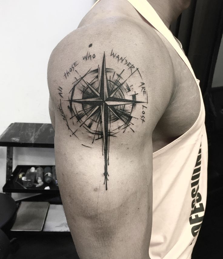 a man with a compass tattoo on his arm