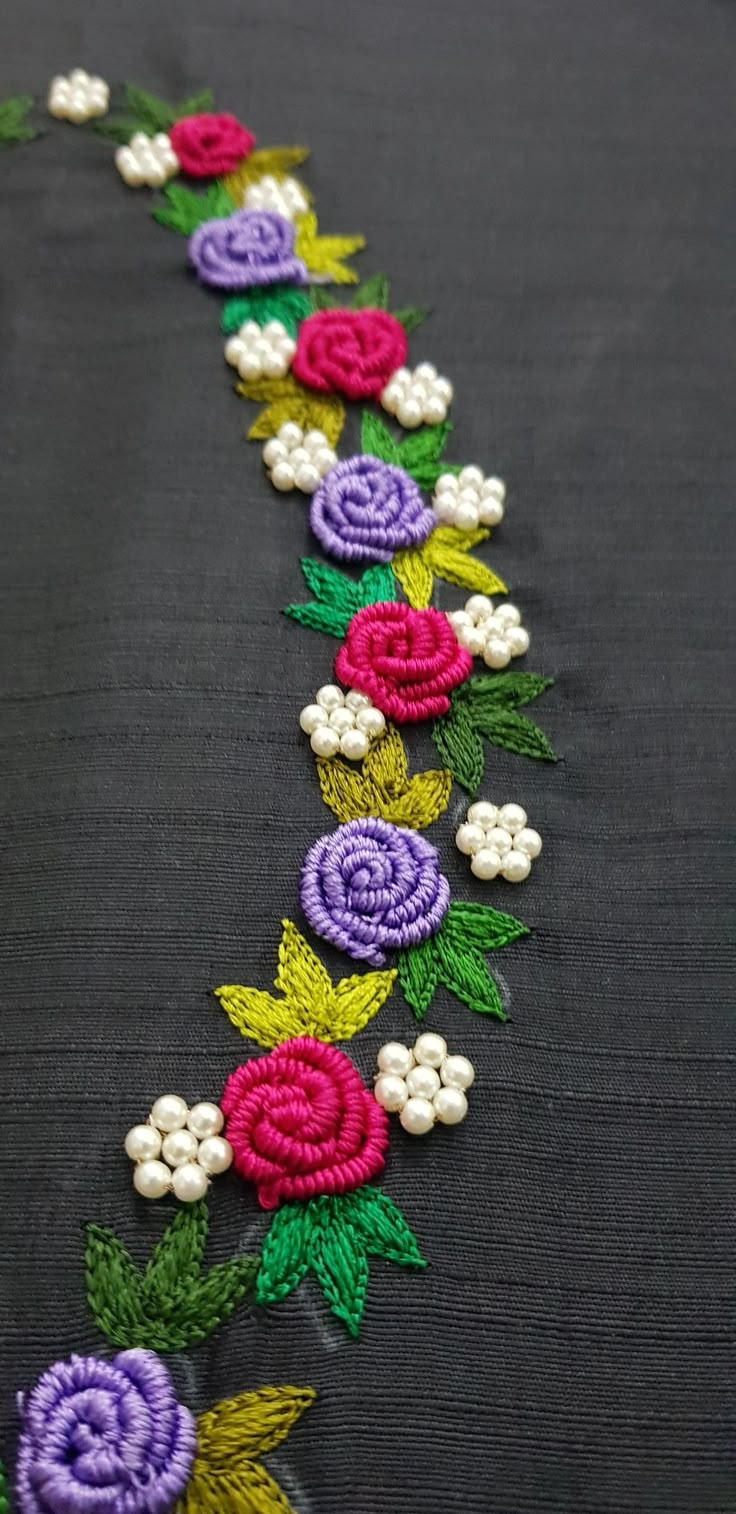 a close up of a table cloth with flowers on it and beads in the middle